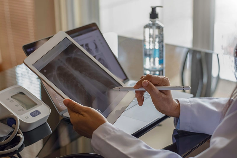 Doctor Reviewing Xray On Tablet